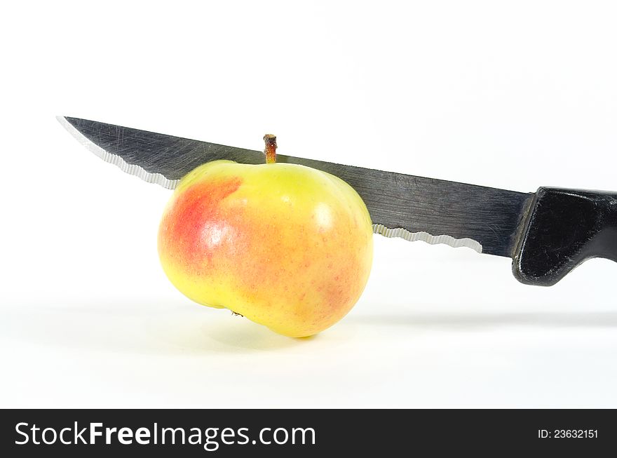 Cutting the mini organic lady apple with knife. Cutting the mini organic lady apple with knife