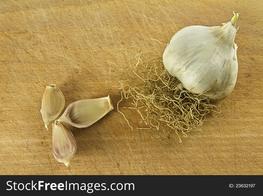 Garlic and three cloves over wooden background