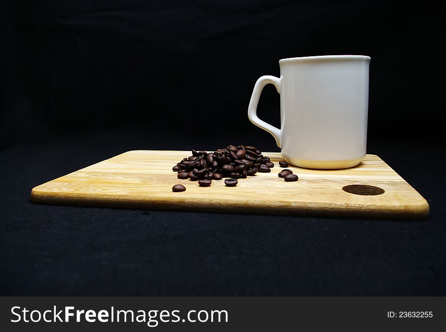 Coffee beans and a cup on a wooden tray. Coffee beans and a cup on a wooden tray