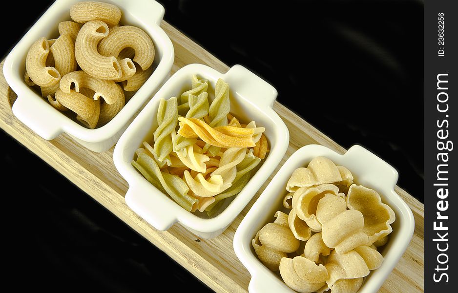 Three sorts of uncooked pasta on a black background. Three sorts of uncooked pasta on a black background