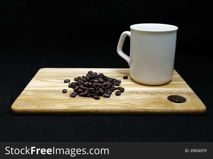Coffee beans and a cup on a wooden tray. Coffee beans and a cup on a wooden tray