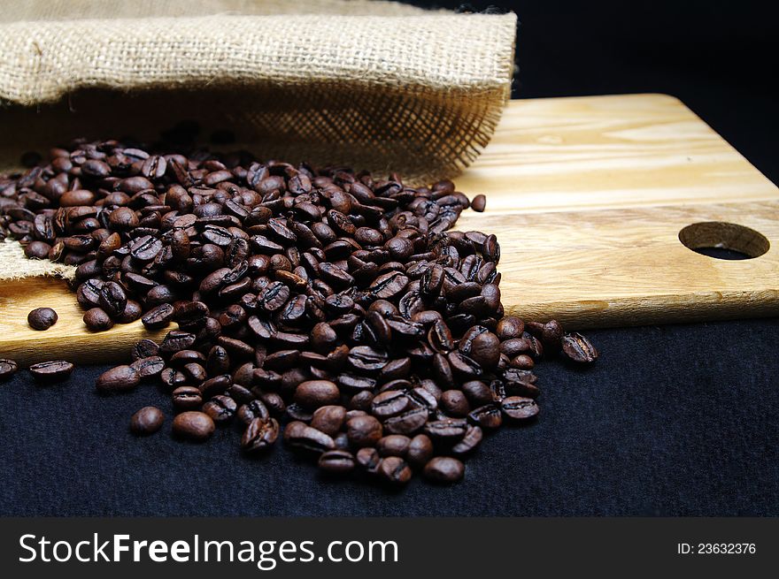 Coffee beans on burlap and a wooden tray. Coffee beans on burlap and a wooden tray