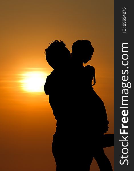 Sunset silhouette a young couple embracing