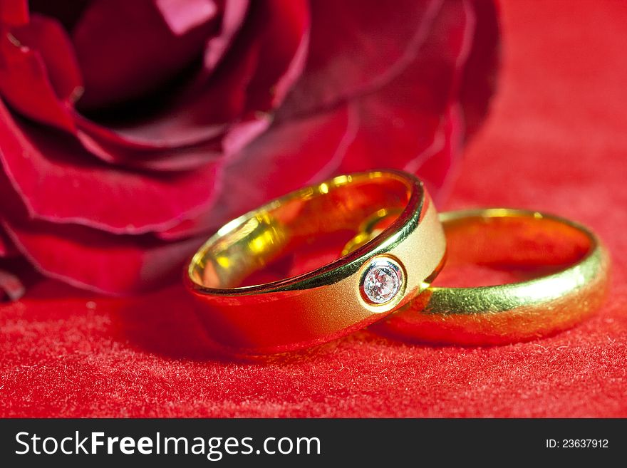 Wedding rings on a red tablecloth, shallow depth of field.