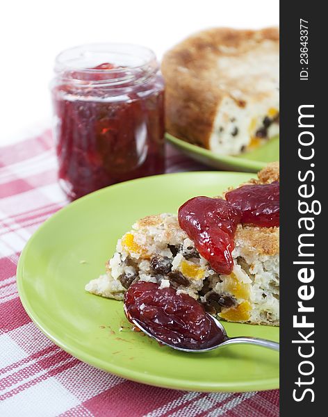 Rice pudding with raisins and dried apricots with strawberry jam.  on white .