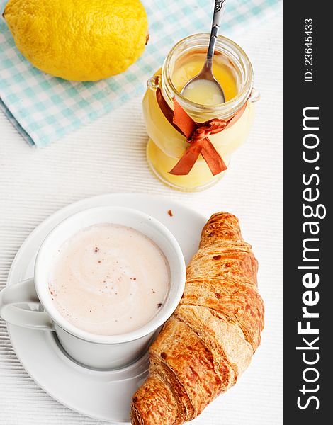 Breakfast with milk, lemon curd and croissants