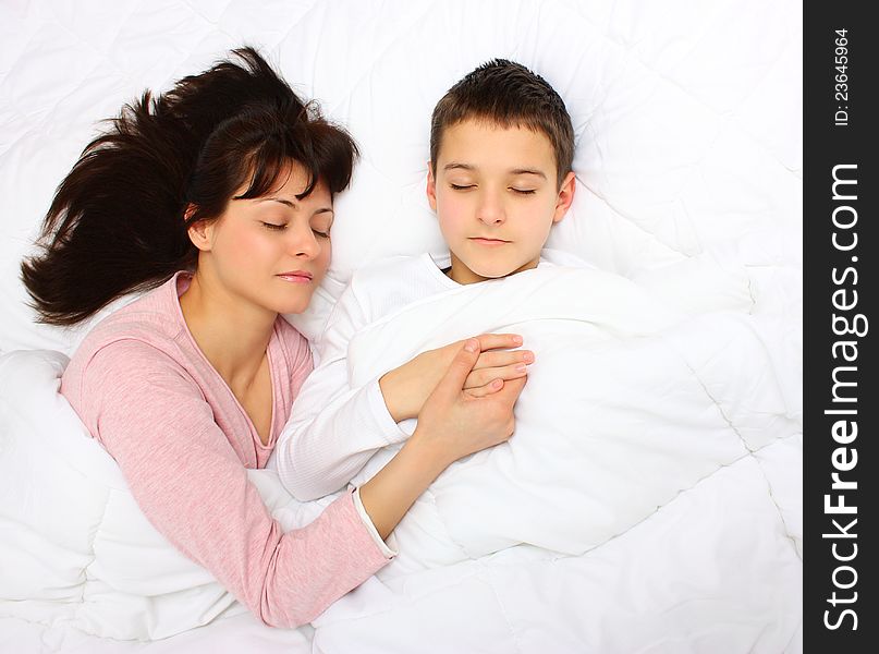 Mother holding her son`s hand , sleeping covered with white blanket. Mother holding her son`s hand , sleeping covered with white blanket