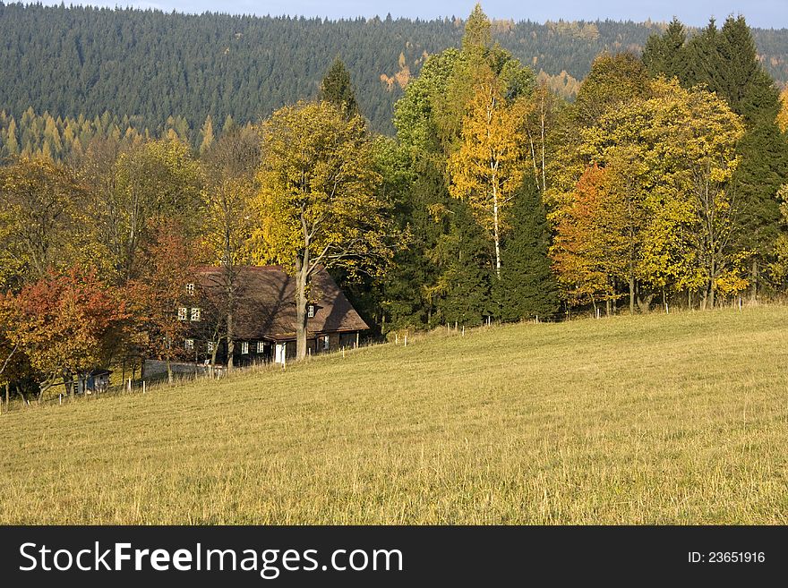 Holiday cottage in the Eagle Mountains, colorful cottage between the trees, autumn day in the Czech countryside, sunny autumn day in the countryside, rural beauty of the Czech Republic. Holiday cottage in the Eagle Mountains, colorful cottage between the trees, autumn day in the Czech countryside, sunny autumn day in the countryside, rural beauty of the Czech Republic