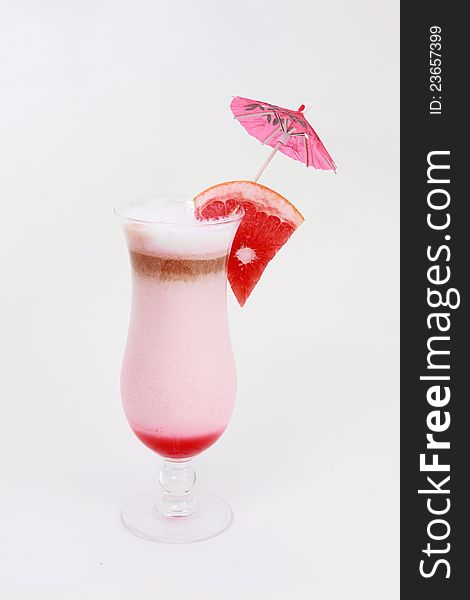 Cocktail glass with fresh grapefruit and umbrella