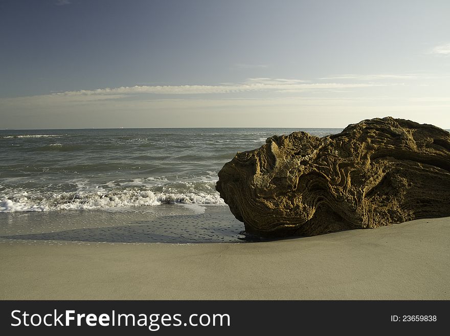 A large stone on the sandy beach. A large stone on the sandy beach.