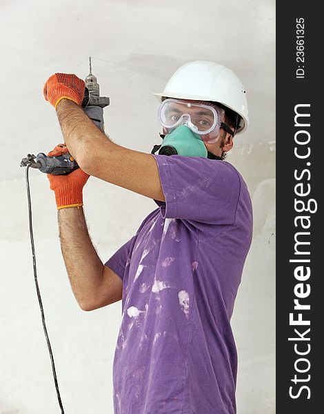 Handyman in a hardhat holding drill. Handyman in a hardhat holding drill