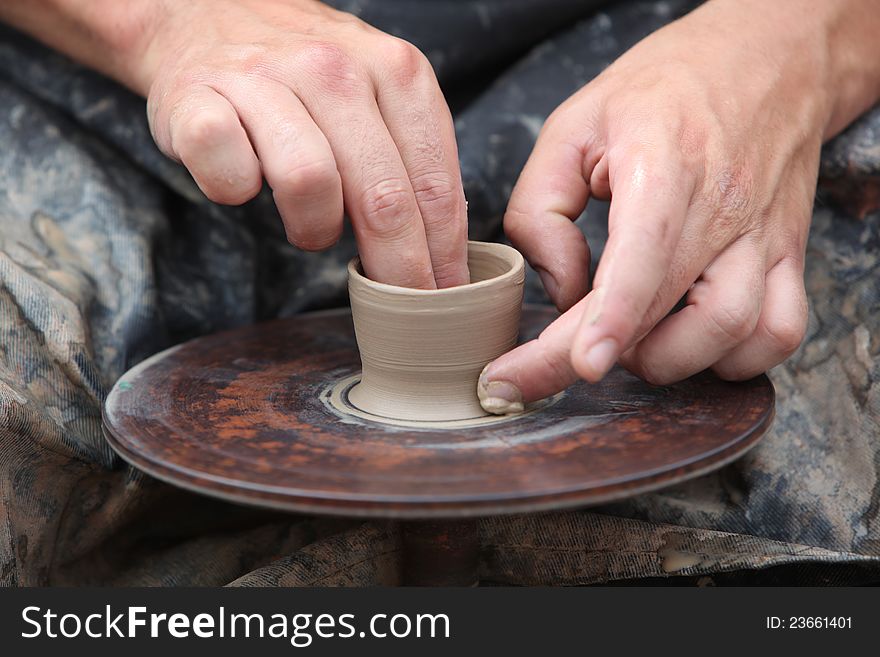 Potter hands creating jar