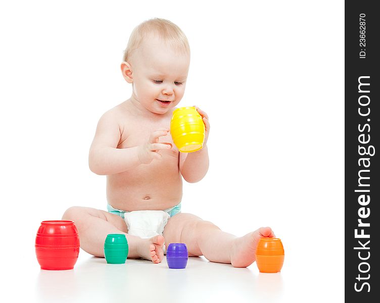 Cute little child is playing with toys while sitting on floor over white. Cute little child is playing with toys while sitting on floor over white