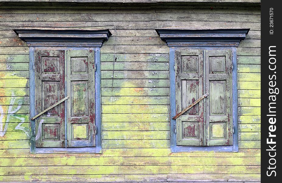 Old house, sun-blind. Broken paint layers. Colored, wooden wall. Old house, sun-blind. Broken paint layers. Colored, wooden wall