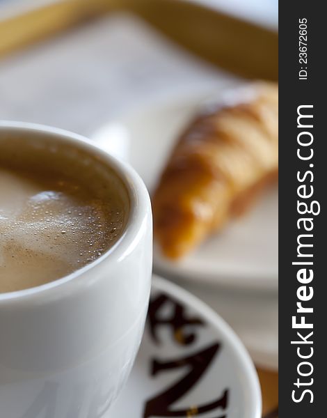 Coffee with milk and freshly made croissant