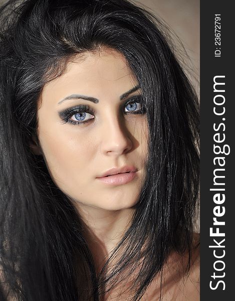 Portrait of a beautiful woman with blue eyes emphasized with black makeup
