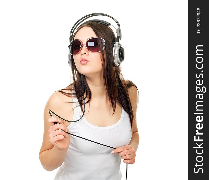 Beautiful girl listens to music through earphones on a white background