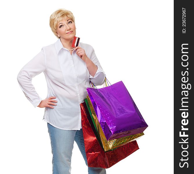 The woman with a credit card and purchases pensively looks upwards and dreams of new buying