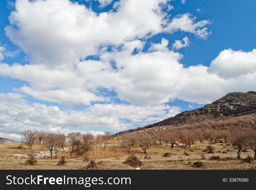 Picturesque countryside landscape with hill and blue sky background with clouds. Picturesque countryside landscape with hill and blue sky background with clouds