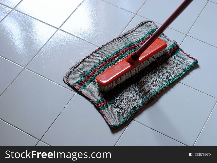 Cleaning clooth and scrubbing brush on a clean and wet floor