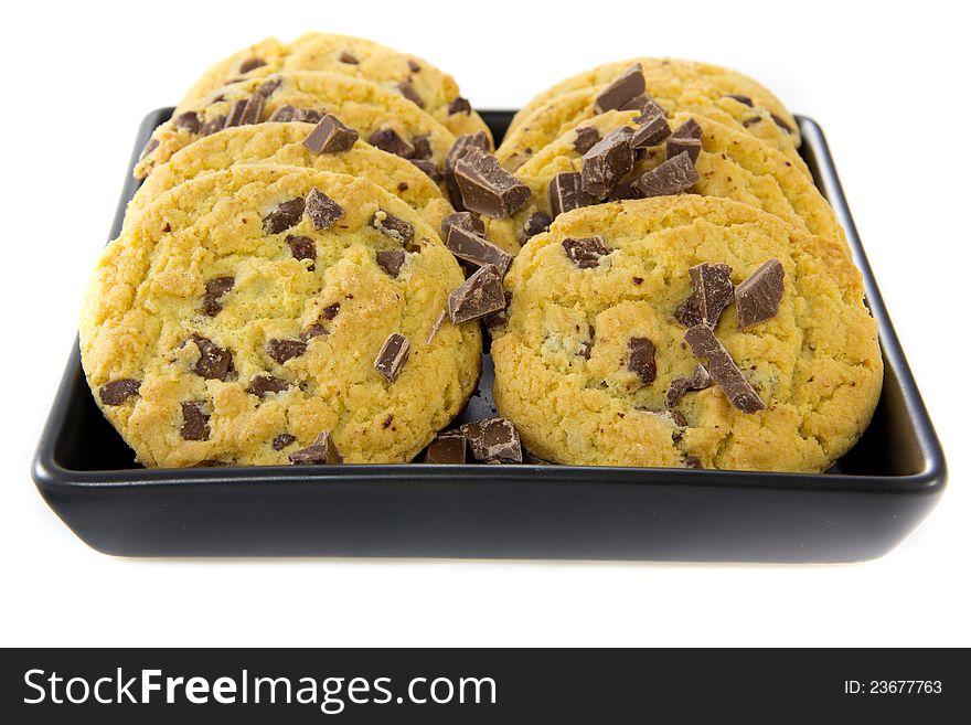 A picture of two stacks of some chocolate cookies with some chocolate on a black plate. A picture of two stacks of some chocolate cookies with some chocolate on a black plate