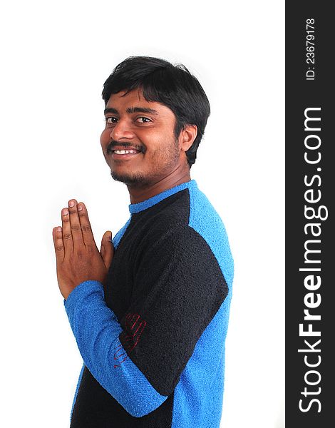 Young guy in praying stance but relaxed and smiling