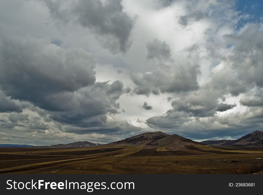 Hill landscape with dramatic sky, grey clouds