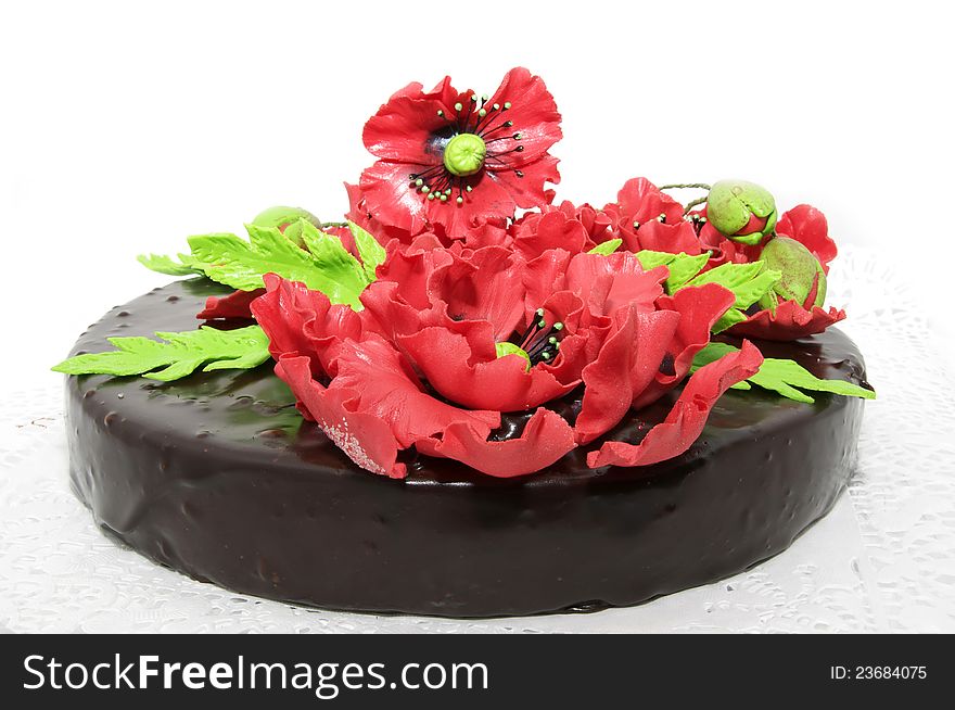 A large chocolate cake decorated with red flowers flowers