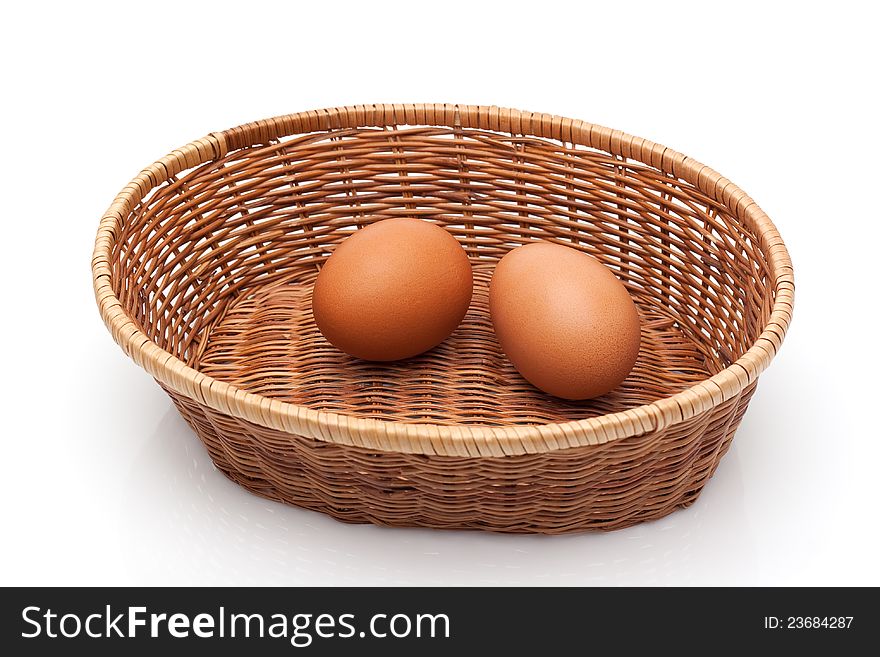 Two eggs in wicker basket on white background