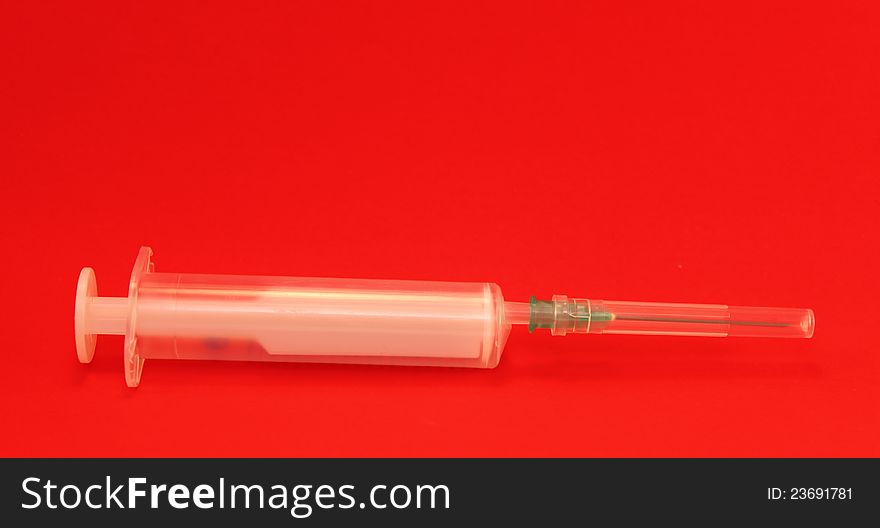 Syringe on a red background
