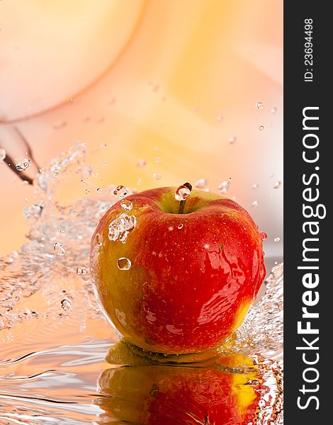 Red ripe apple water splash over abstract background