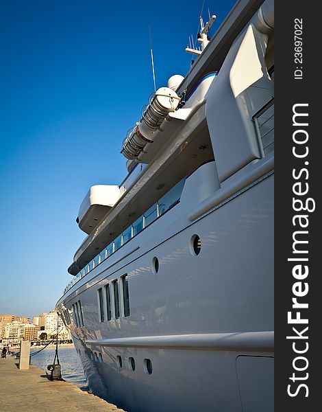 Large yacht docked in port under blue sky