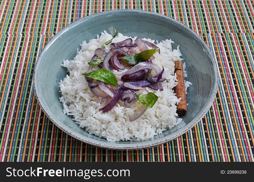 Bowl of white rice with fried red onions, curry leaves and cinnamon. Bowl of white rice with fried red onions, curry leaves and cinnamon