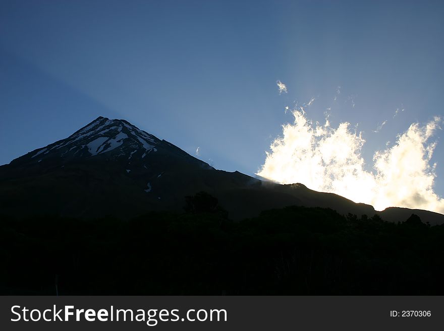 Mount Egmont at sunset with a ray of light. Mount Egmont at sunset with a ray of light