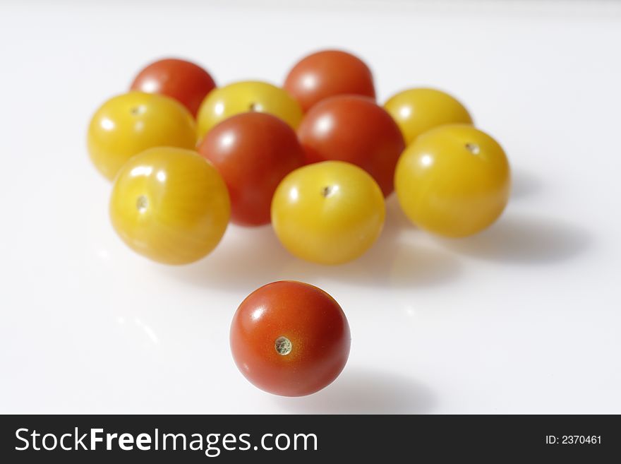 Red and yellow tomates on the white