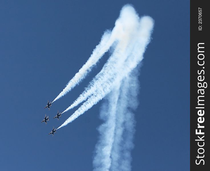 Four fighter jets flying in formation against a clear blue sky