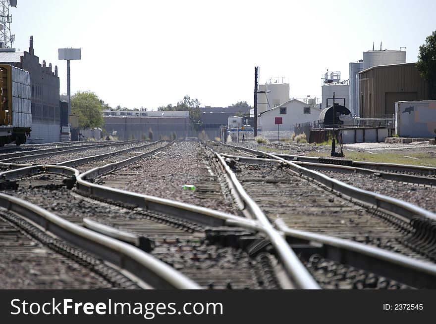 Depicts a rural railroad switch yard. Depicts a rural railroad switch yard