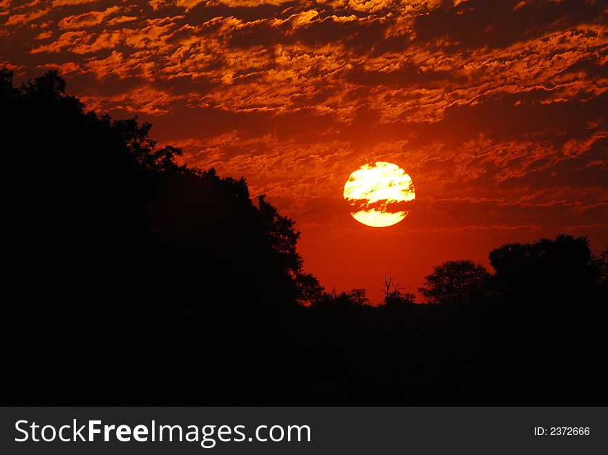 Sun sets into a bleeding sky in the Kruger Park, South Africa. Sun sets into a bleeding sky in the Kruger Park, South Africa