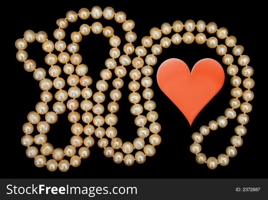 Heart and pearly necklace, isolated on black background