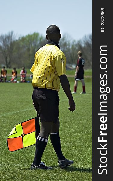 Soccer official at a soccer game with a colorful flag. Soccer official at a soccer game with a colorful flag