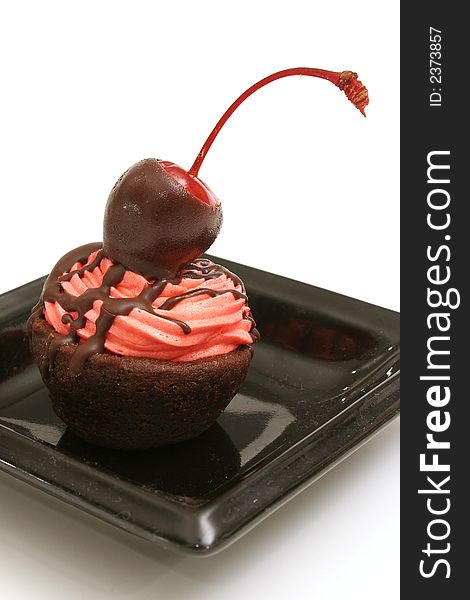 Isolated photo of a cherry topped brownie bite up close on white