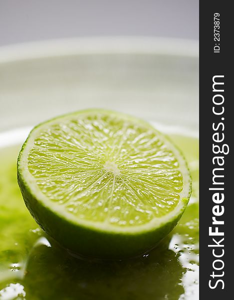 Green lime on the plate with juice