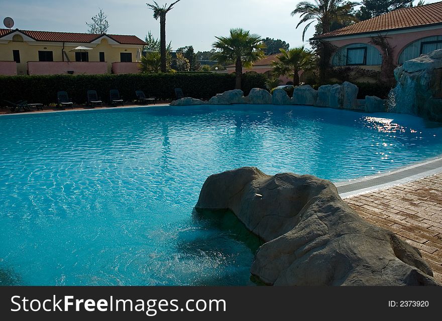 Clear azure pool water of a luxury resort in a hot sunny day. Clear azure pool water of a luxury resort in a hot sunny day