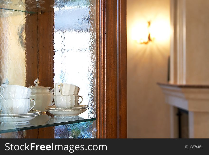 Tea cups behind glass in a kitchen case