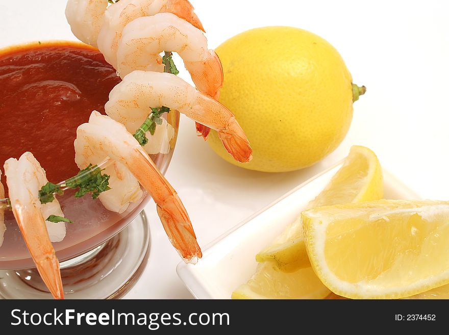 Isolated photo of shrimp coctail on white with lemons