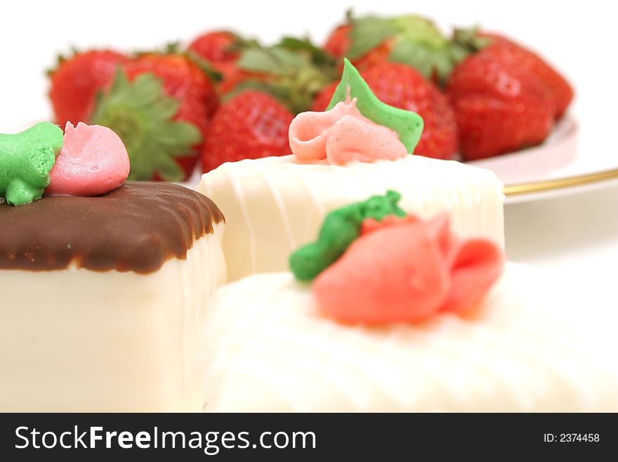 Isolated photo of a petit fours and strawberrys on white