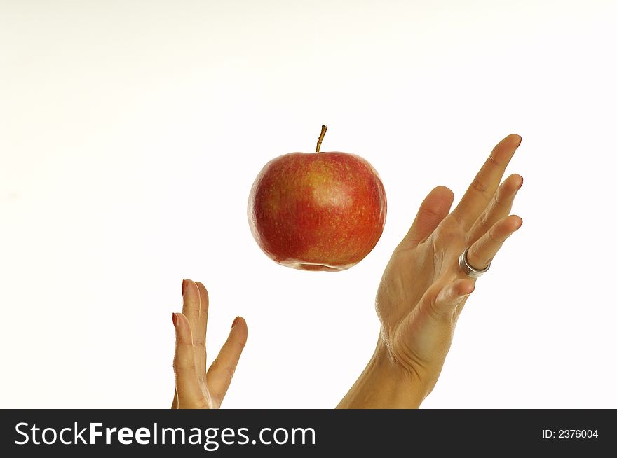 Girl throwing apple into the air over a white background