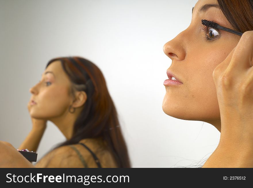 Young beautiful girl applies makeup