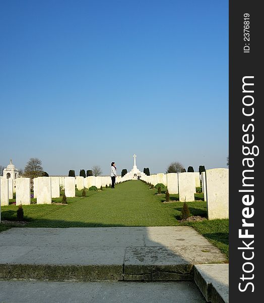 A solitary figure walks up between rows and rows of white headstones in a cemetery filled with graves from the First World War. A solitary figure walks up between rows and rows of white headstones in a cemetery filled with graves from the First World War
