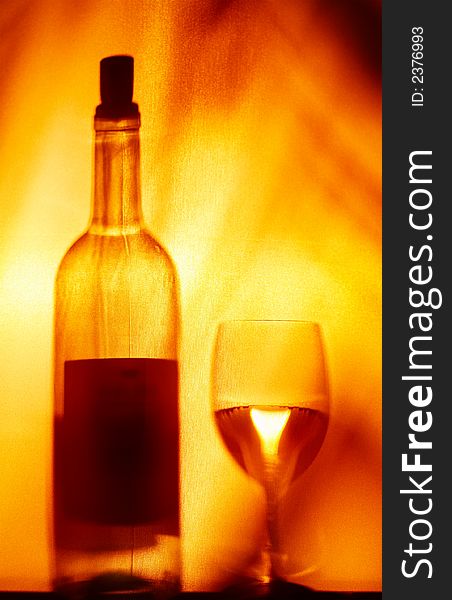 View of  wineglass and bottle silhouette on fire color back. View of  wineglass and bottle silhouette on fire color back